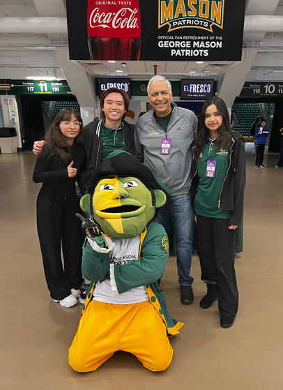 Students and Costello dean Ajay Vinzé pose with the Patriot mascot in lobby of EagleBank Arena